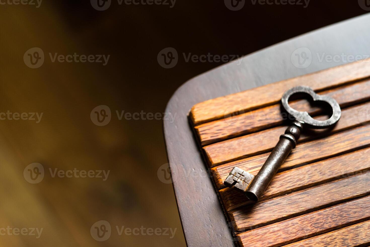 the old key lies on an old wooden table, natural textures, the concept of discoveries, secrets, answers photo