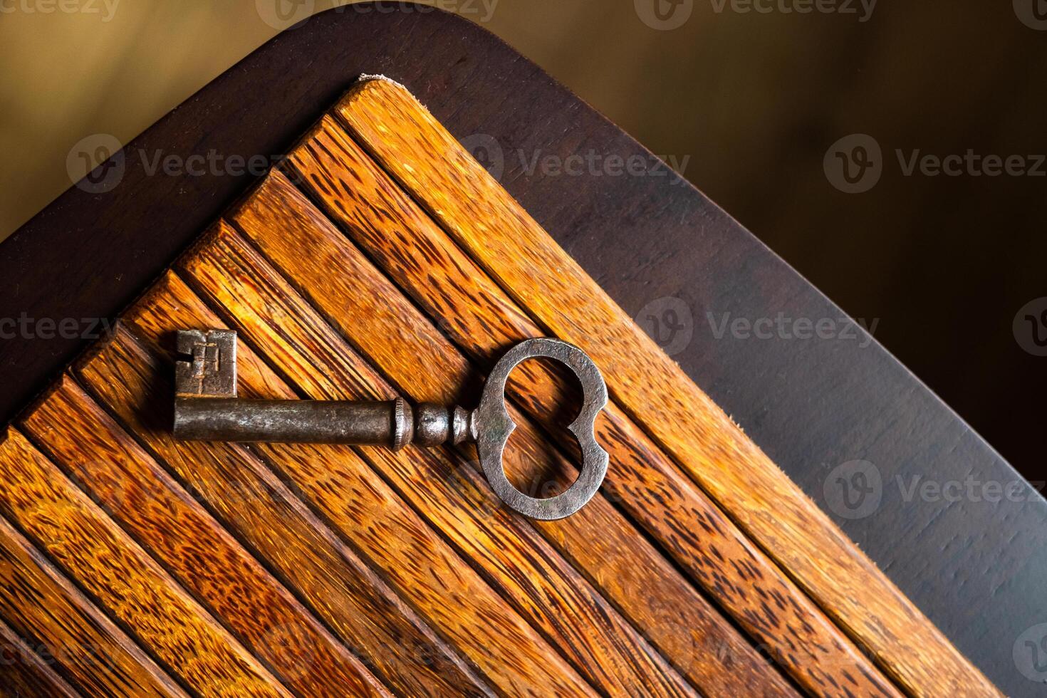 the old key lies on an old wooden table, natural textures, the concept of discoveries, secrets, answers photo