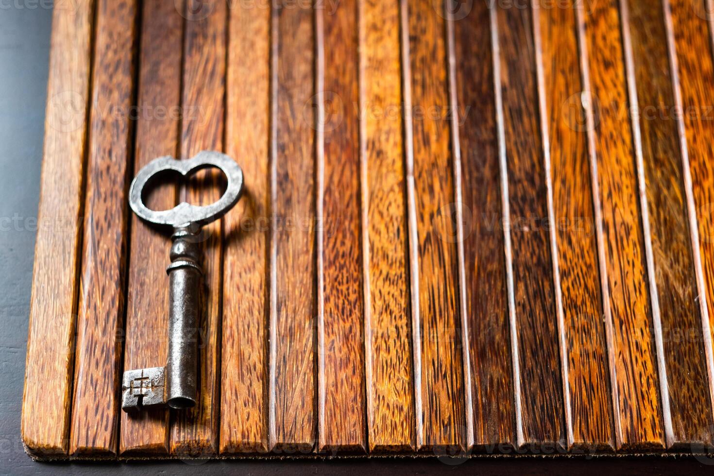 the old key lies on an old wooden table, natural textures, the concept of discoveries, secrets, answers photo