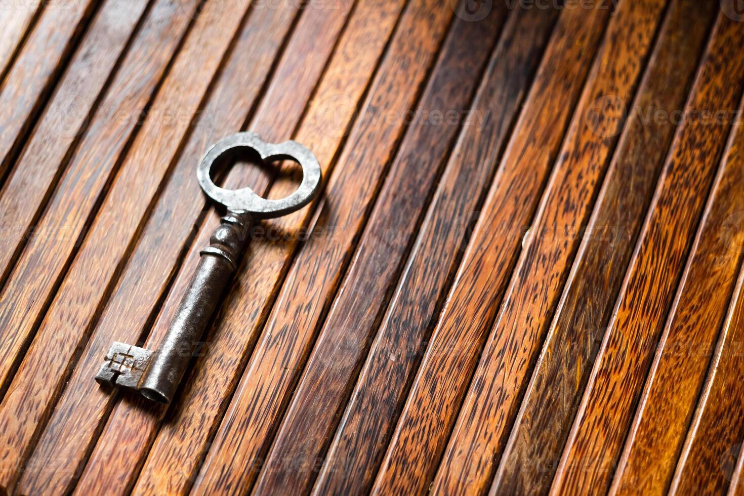 the old key lies on an old wooden table, natural textures, the concept of discoveries, secrets, answers photo