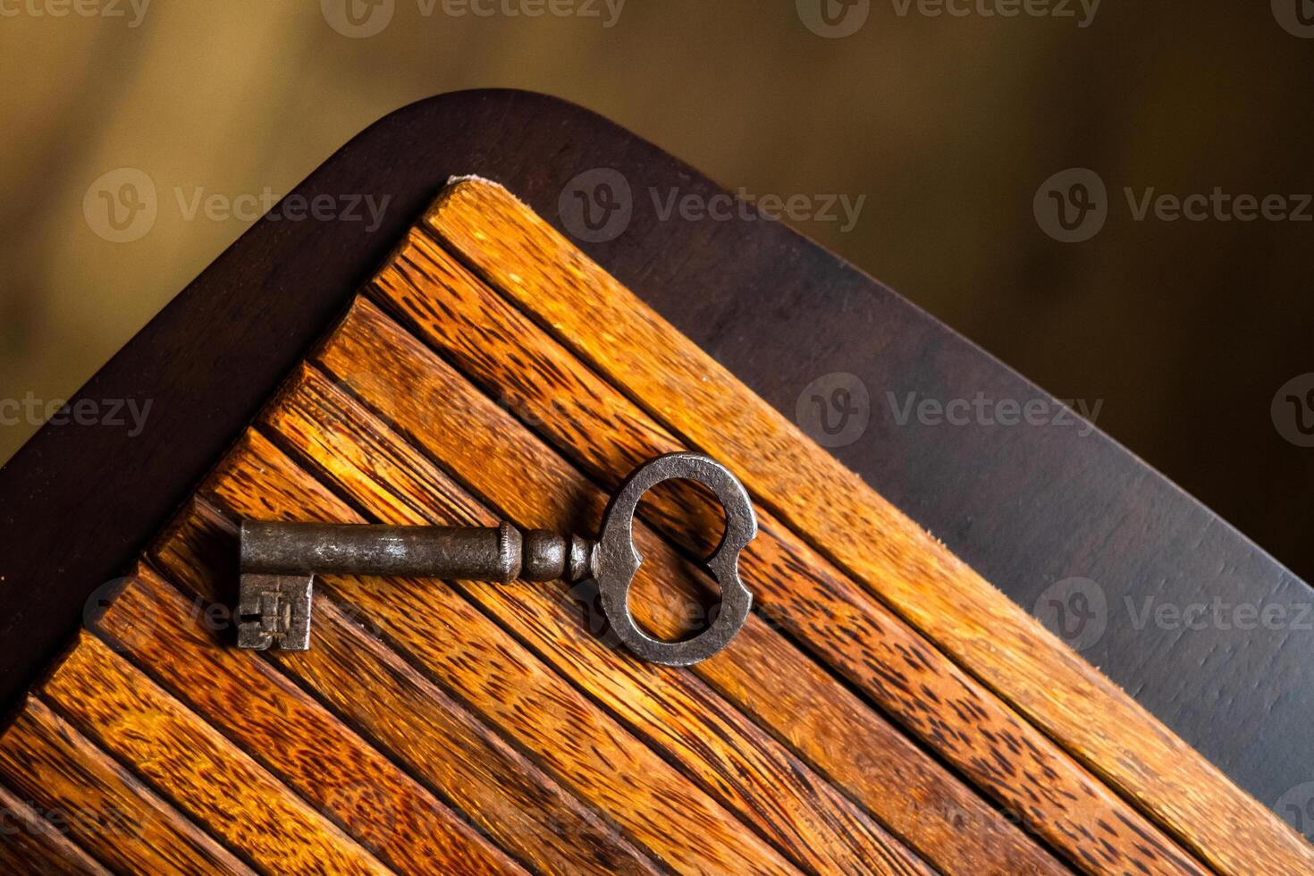 the old key lies on an old wooden table, natural textures, the concept of discoveries, secrets, answers photo