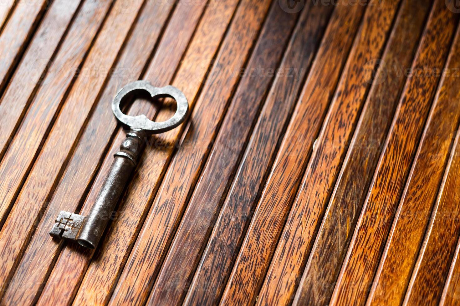 the old key lies on an old wooden table, natural textures, the concept of discoveries, secrets, answers photo