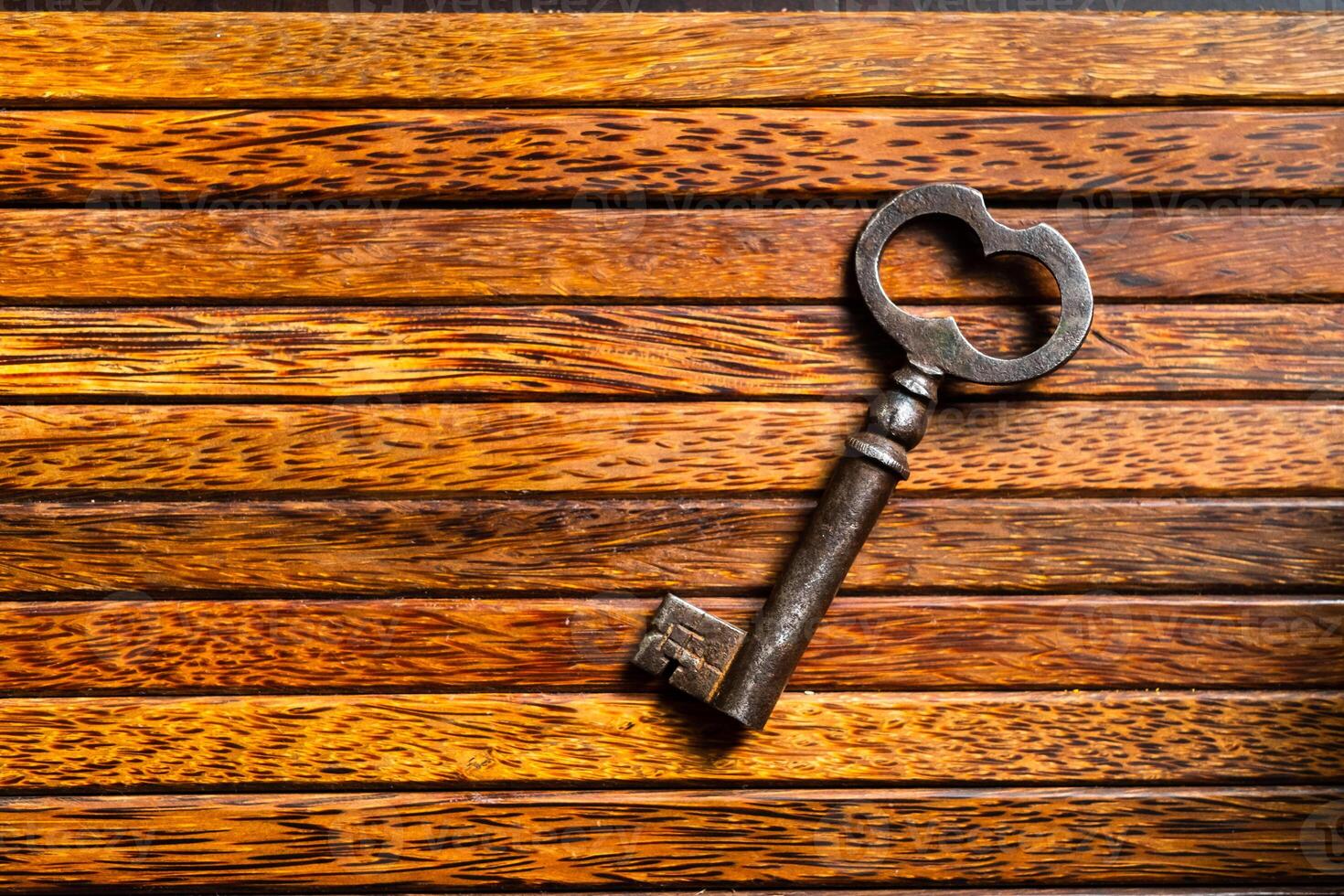 the old key lies on an old wooden table, natural textures, the concept of discoveries, secrets, answers photo