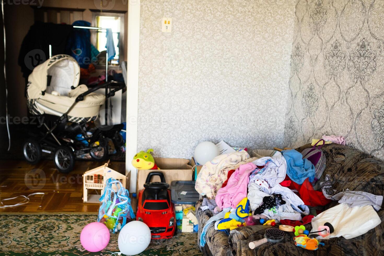 A mess in the room. A lot of things are lying around the apartment. House is in the room photo
