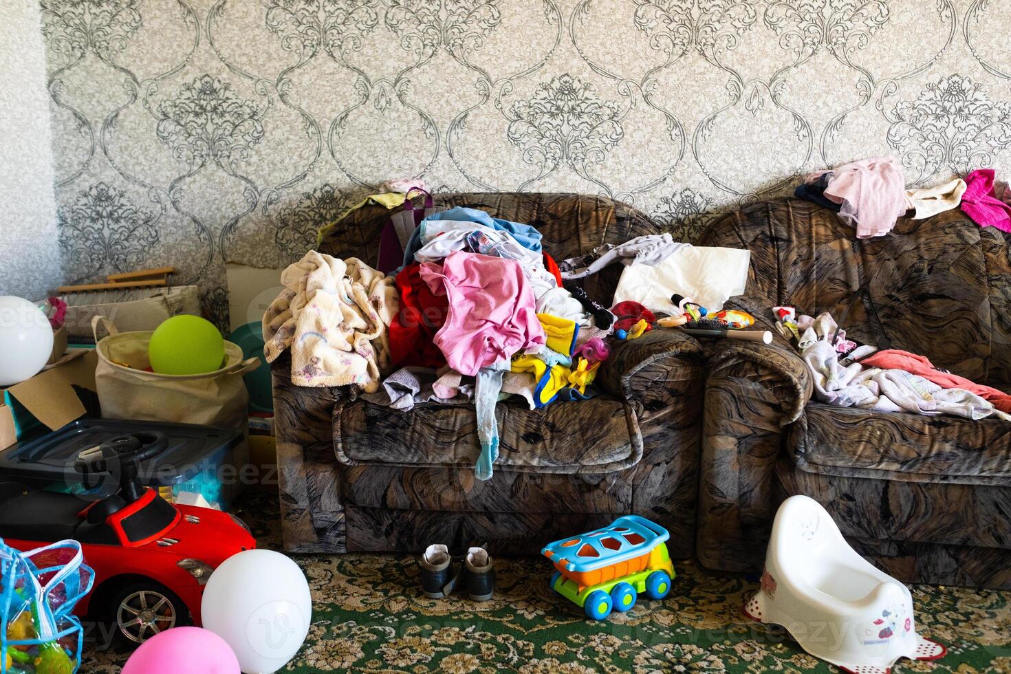 A mess in the room. A lot of things are lying around the apartment. House is in the room photo