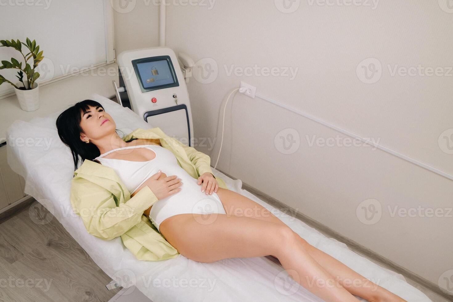 a slender woman is lying on a bed in a beauty salon before laser hair removal. look at the delicate skin on your feet and want to make it more hairless photo
