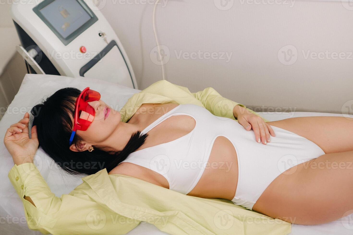 a slender woman is lying on a bed in a beauty salon before laser hair removal. look at the delicate skin on your feet and want to make it more hairless photo