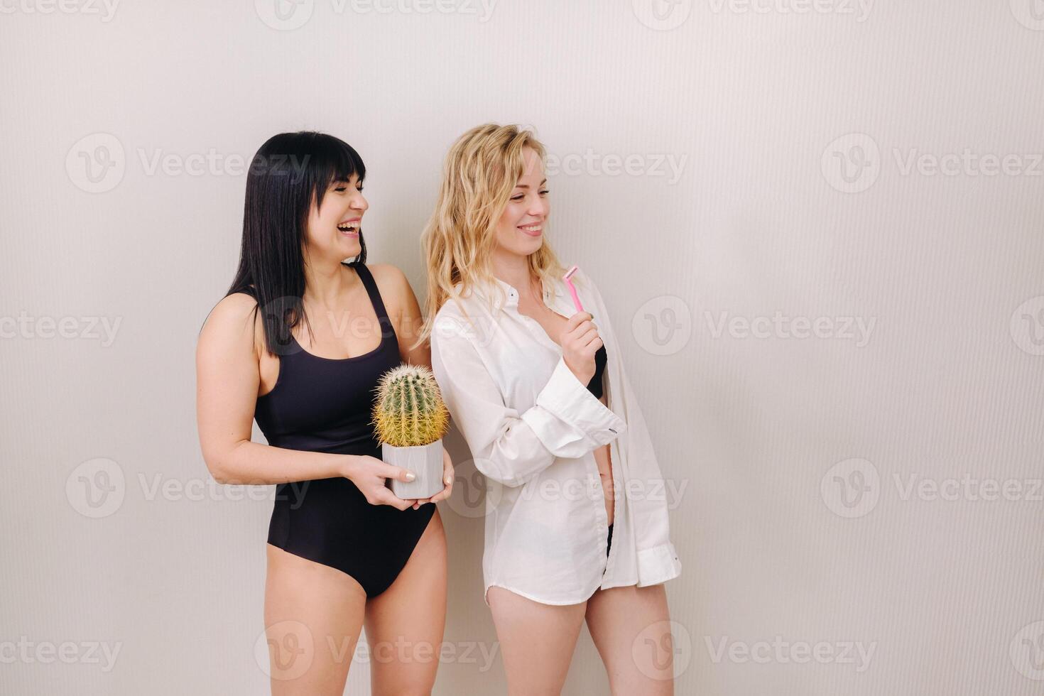 Cactus concept. Unshaven body . One girl is holding a cactus in her hands, and the second girl is holding a razor. Symbol of unshaven body parts photo