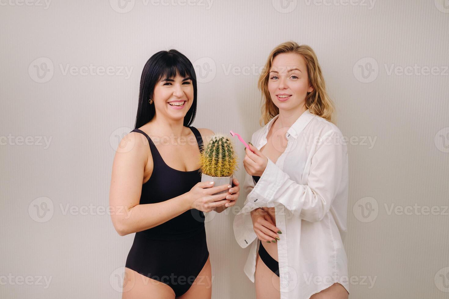 Cactus concept. Unshaven body . One girl is holding a cactus in her hands, and the second girl is holding a razor. Symbol of unshaven body parts photo