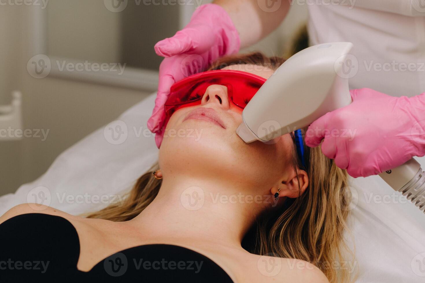 A girl in black underwear gets laser hair removal on her body in the salon photo