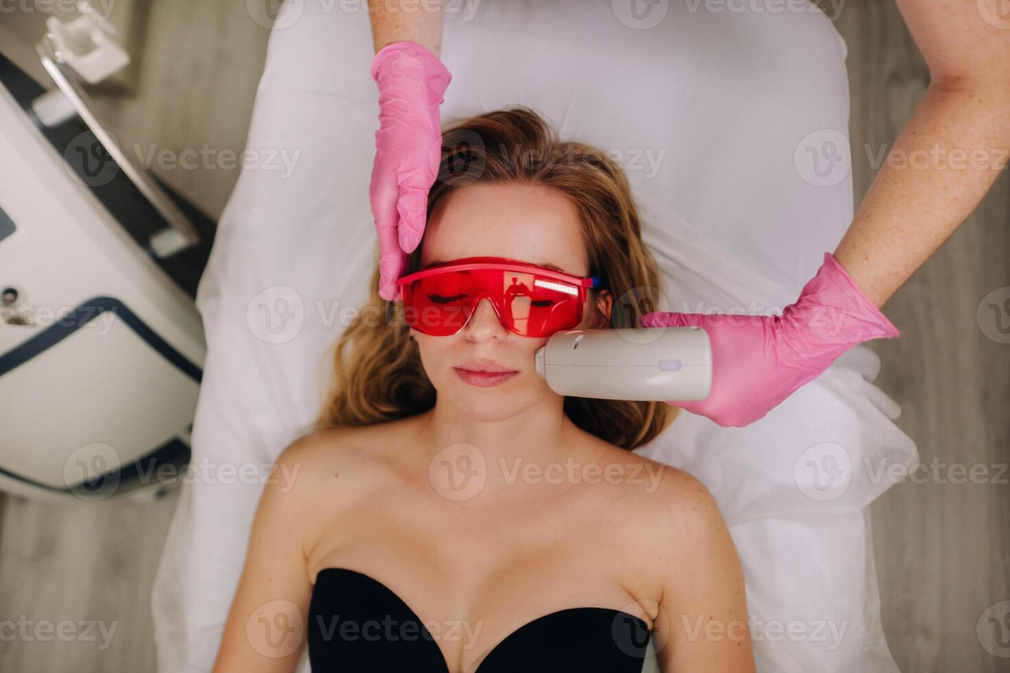 A girl in black underwear gets laser hair removal on her body in the salon photo