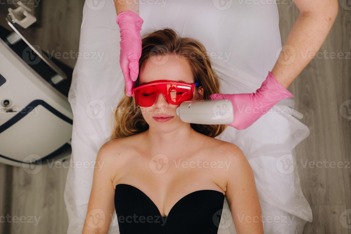 A girl in black underwear gets laser hair removal on her body in the salon photo