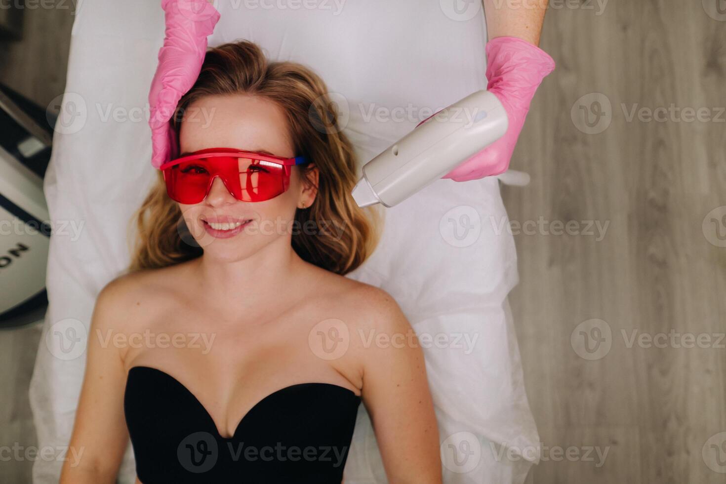 A girl in black underwear gets laser hair removal on her body in the salon photo