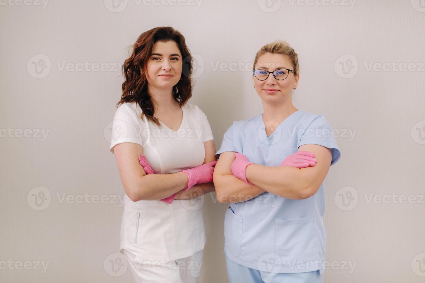 Portrait of two qualified cosmetologists-women smiling confidently in a medical center photo