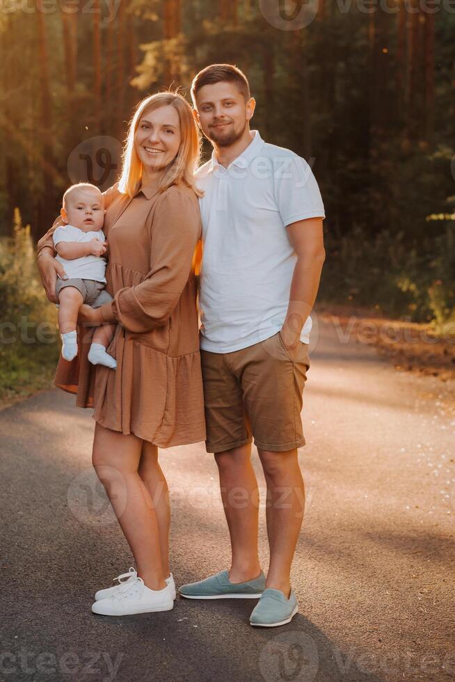 Happy family of three in the summer in the park in nature photo