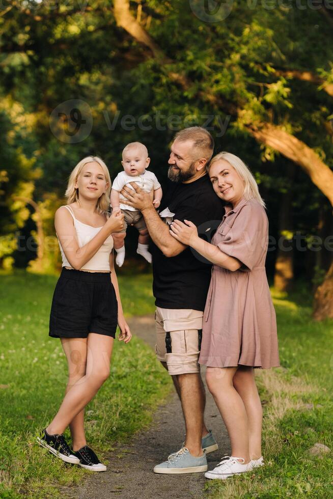 Happy family in the park of four people in the summer in the park in nature photo