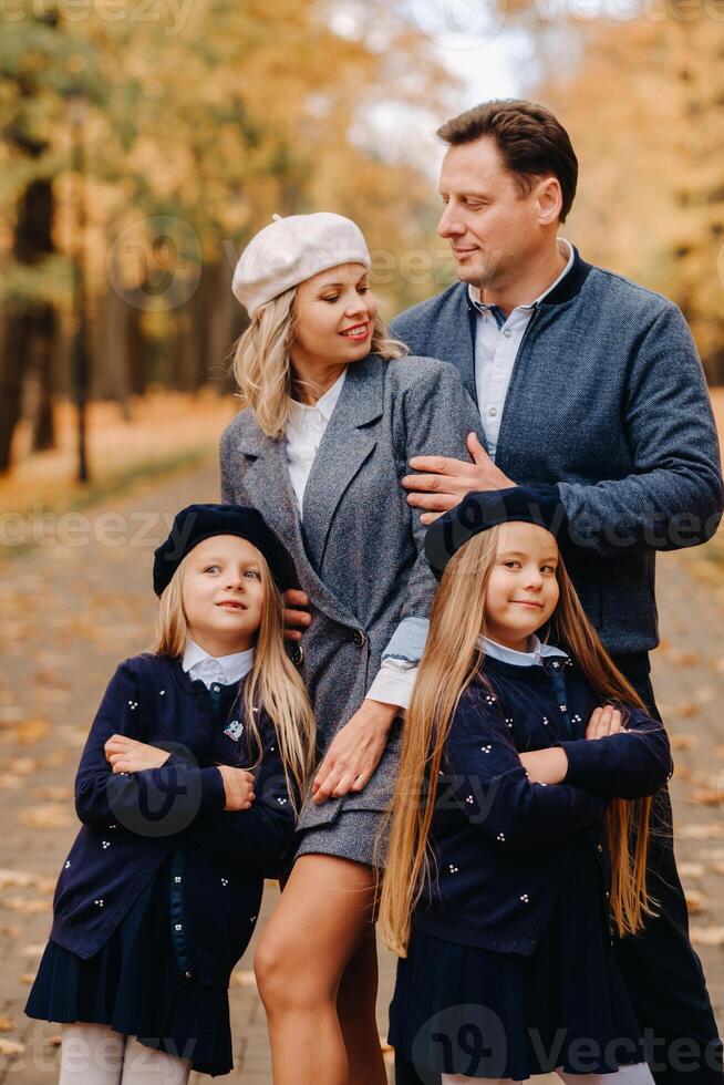 A large family walks in the park in the fall. Happy people in the autumn park photo