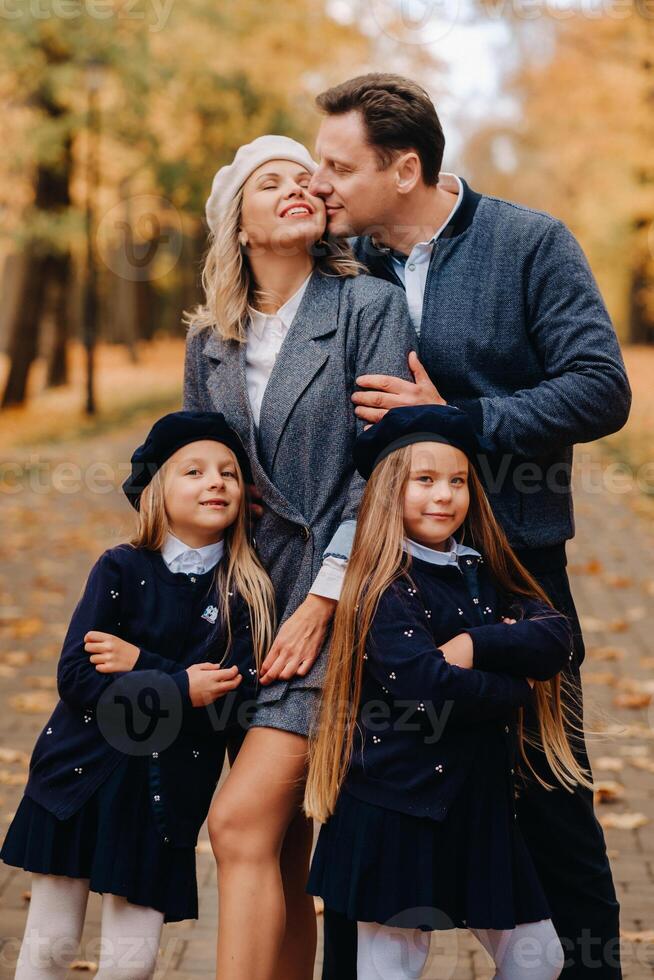 A large family walks in the park in the fall. Happy people in the autumn park photo