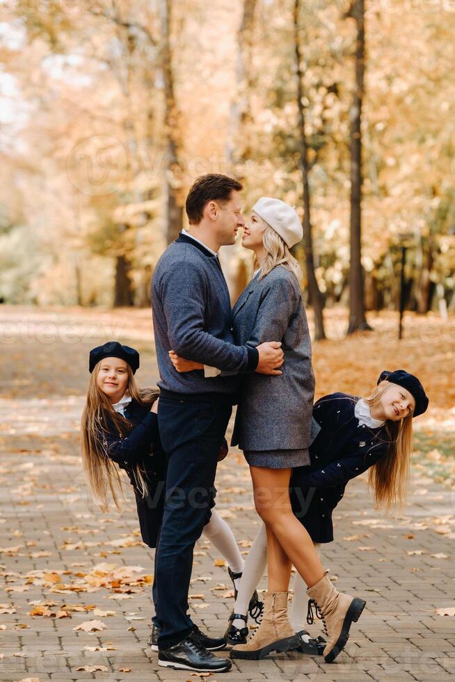 A large family walks in the park in the fall. Happy people in the autumn park photo