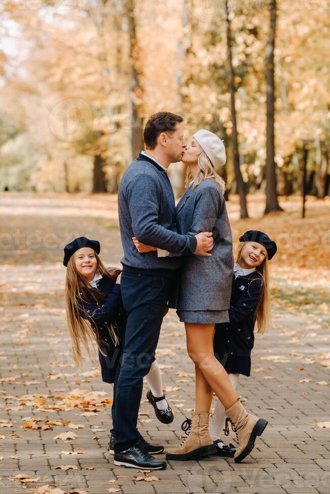 A large family walks in the park in the fall. Happy people in the autumn park photo