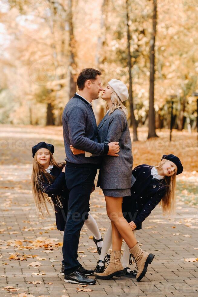 A large family walks in the park in the fall. Happy people in the autumn park photo