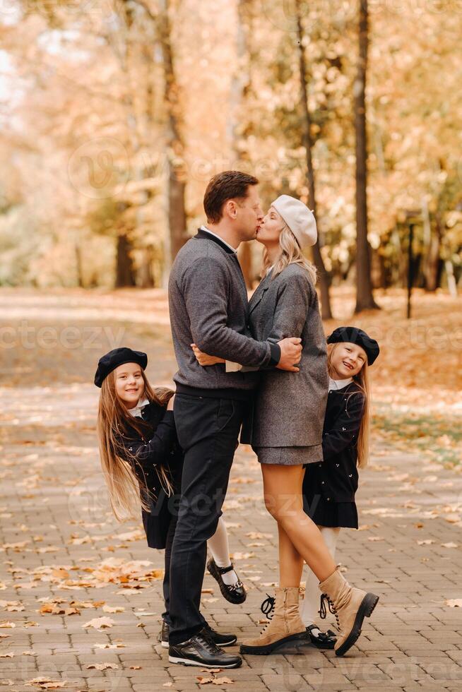 A large family walks in the park in the fall. Happy people in the autumn park photo