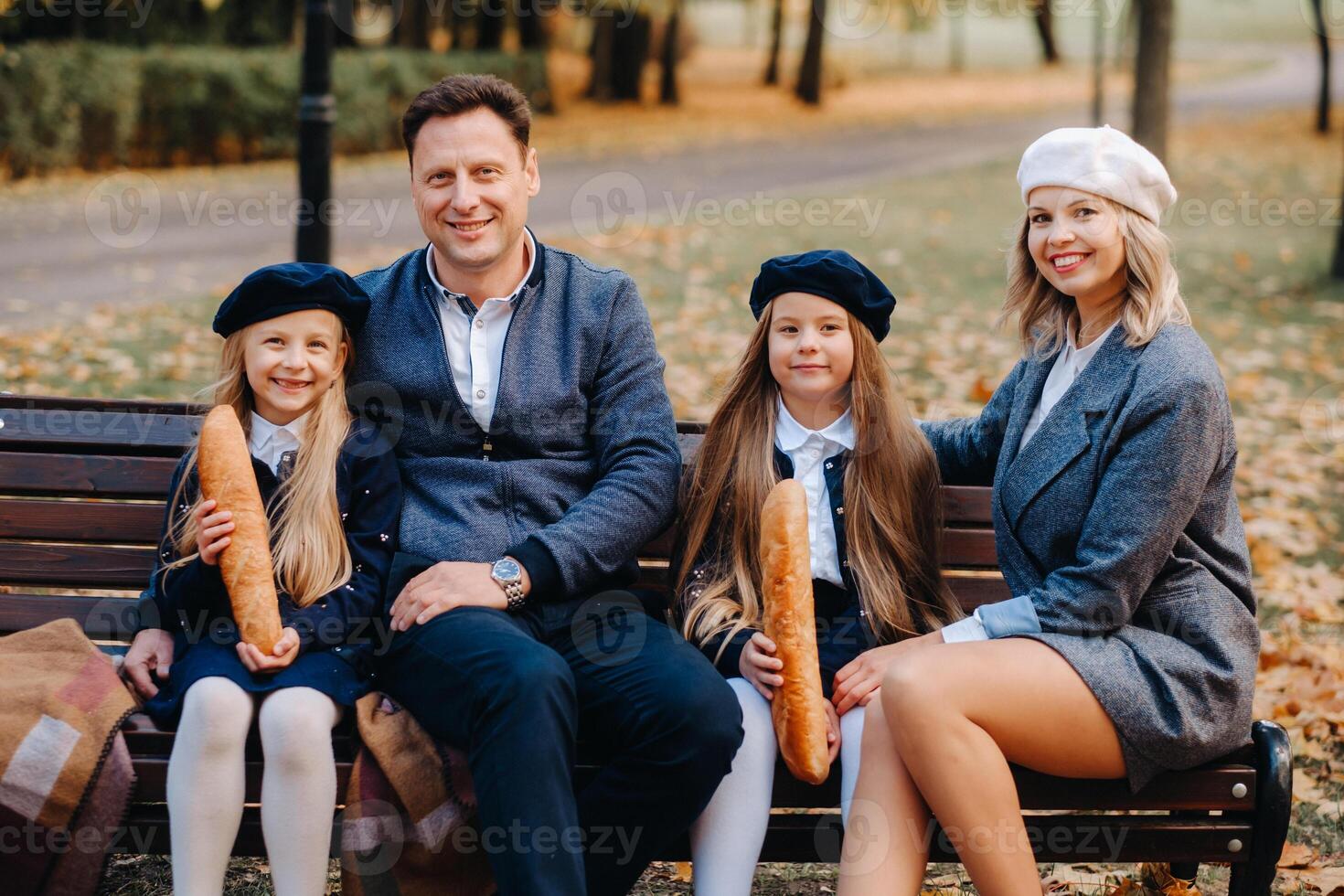 A large family is sitting on a bench in an autumn park. Happy people in the autumn park photo