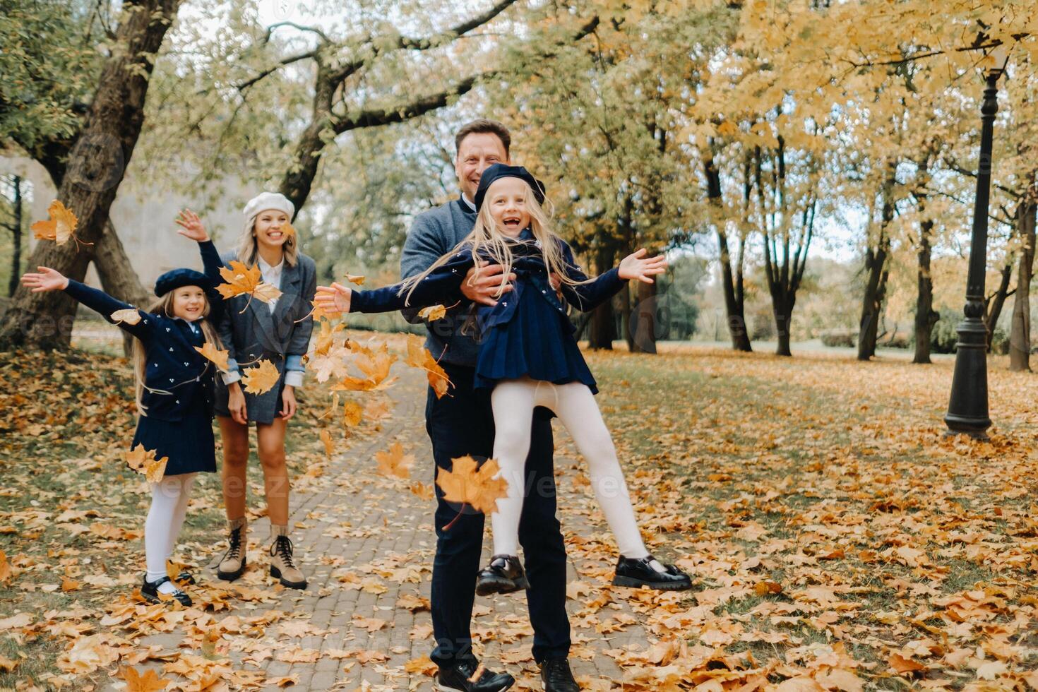 A large family walks in the park in the fall. Happy people in the autumn park photo