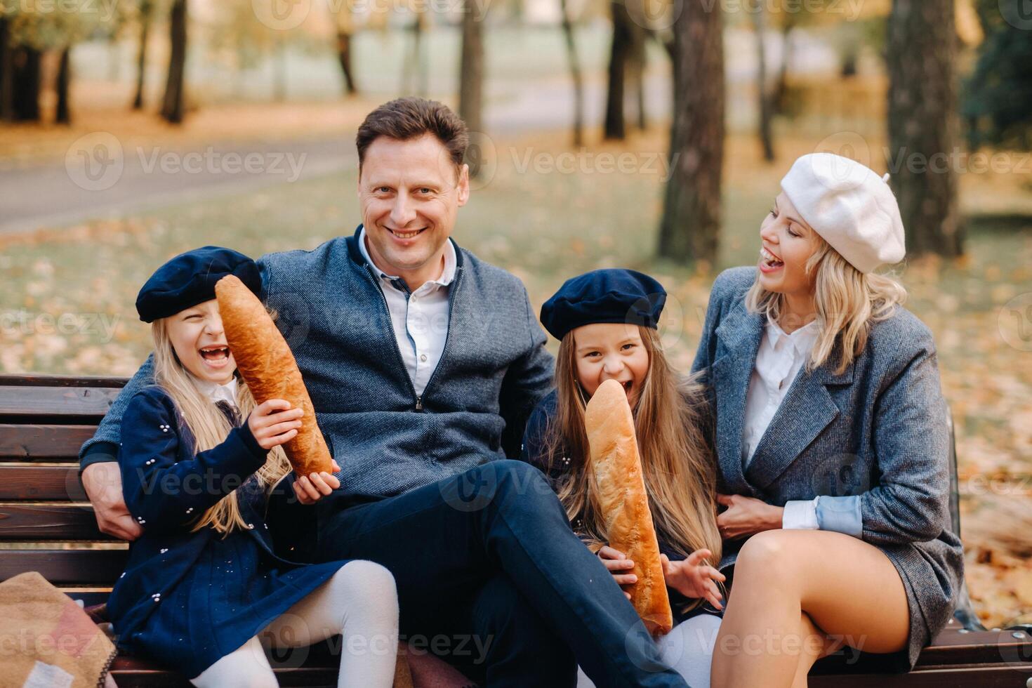 A large family is sitting on a bench in an autumn park. Happy people in the autumn park photo