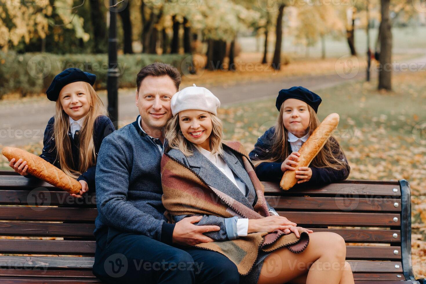 A large family is sitting on a bench in an autumn park. Happy people in the autumn park photo