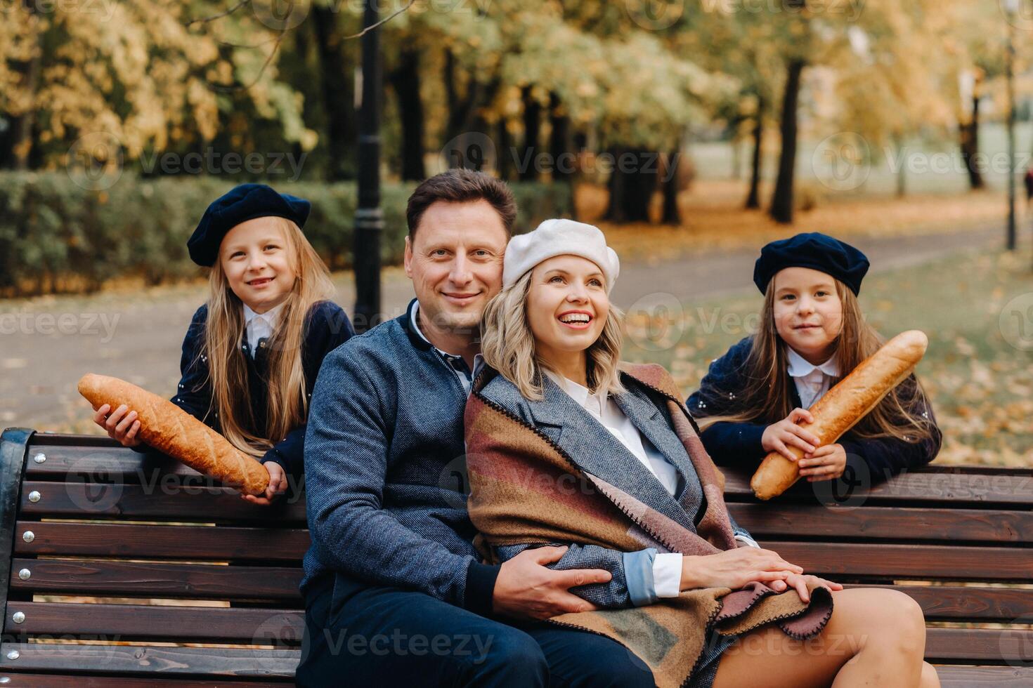 A large family is sitting on a bench in an autumn park. Happy people in the autumn park photo