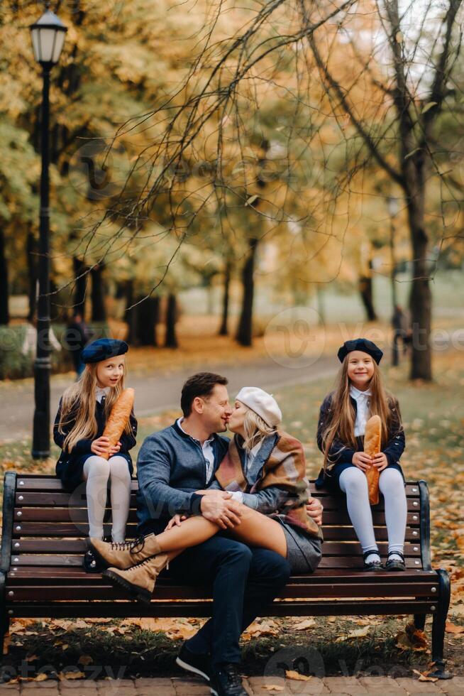 A large family is sitting on a bench in an autumn park. Happy people in the autumn park photo