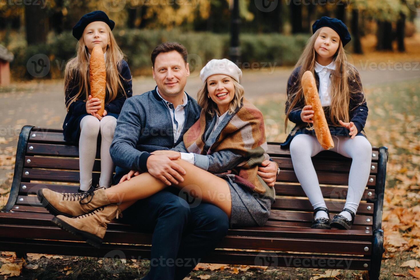 A large family is sitting on a bench in an autumn park. Happy people in the autumn park photo