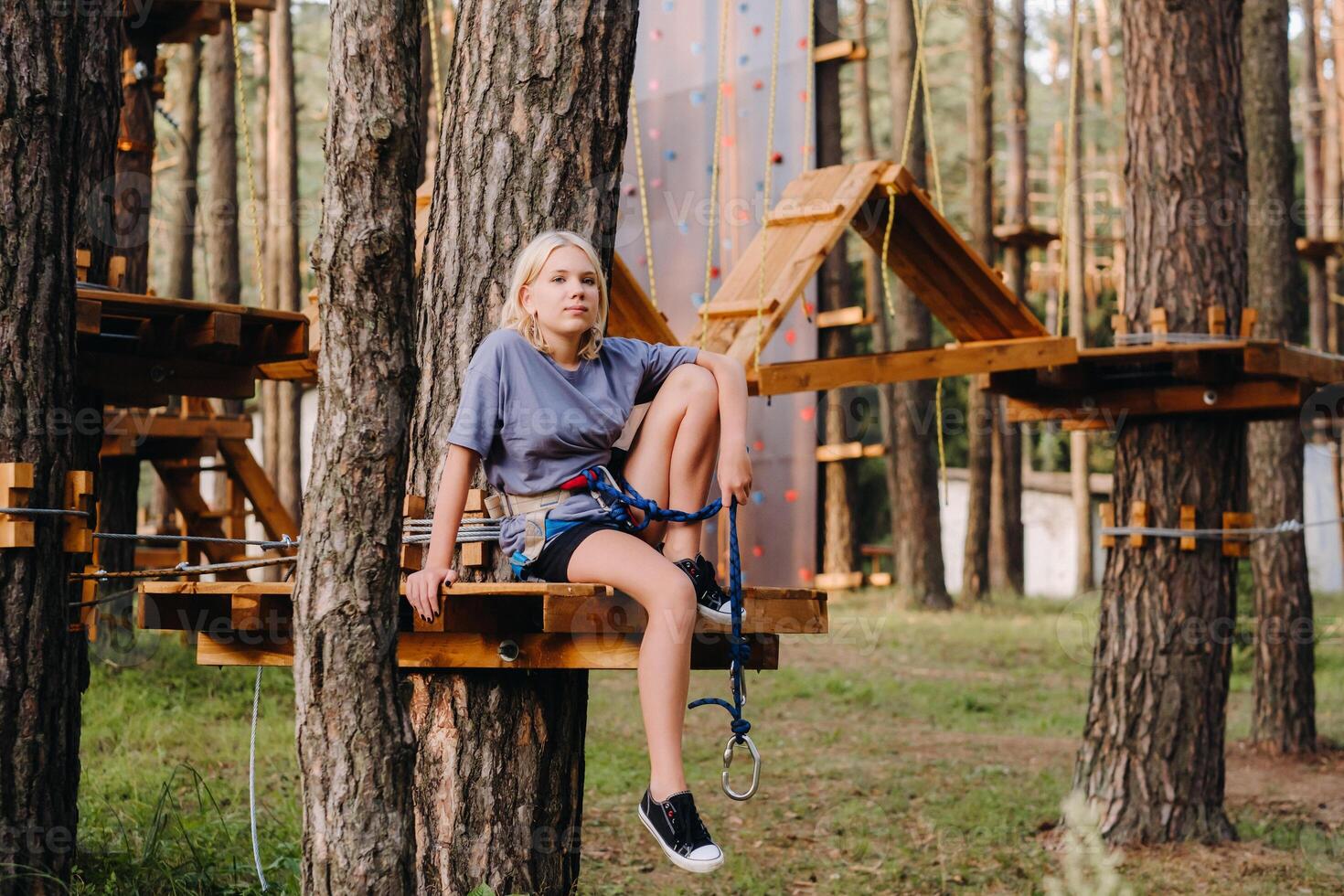 A girl passes an obstacle in a rope town. A girl in a forest rope park photo