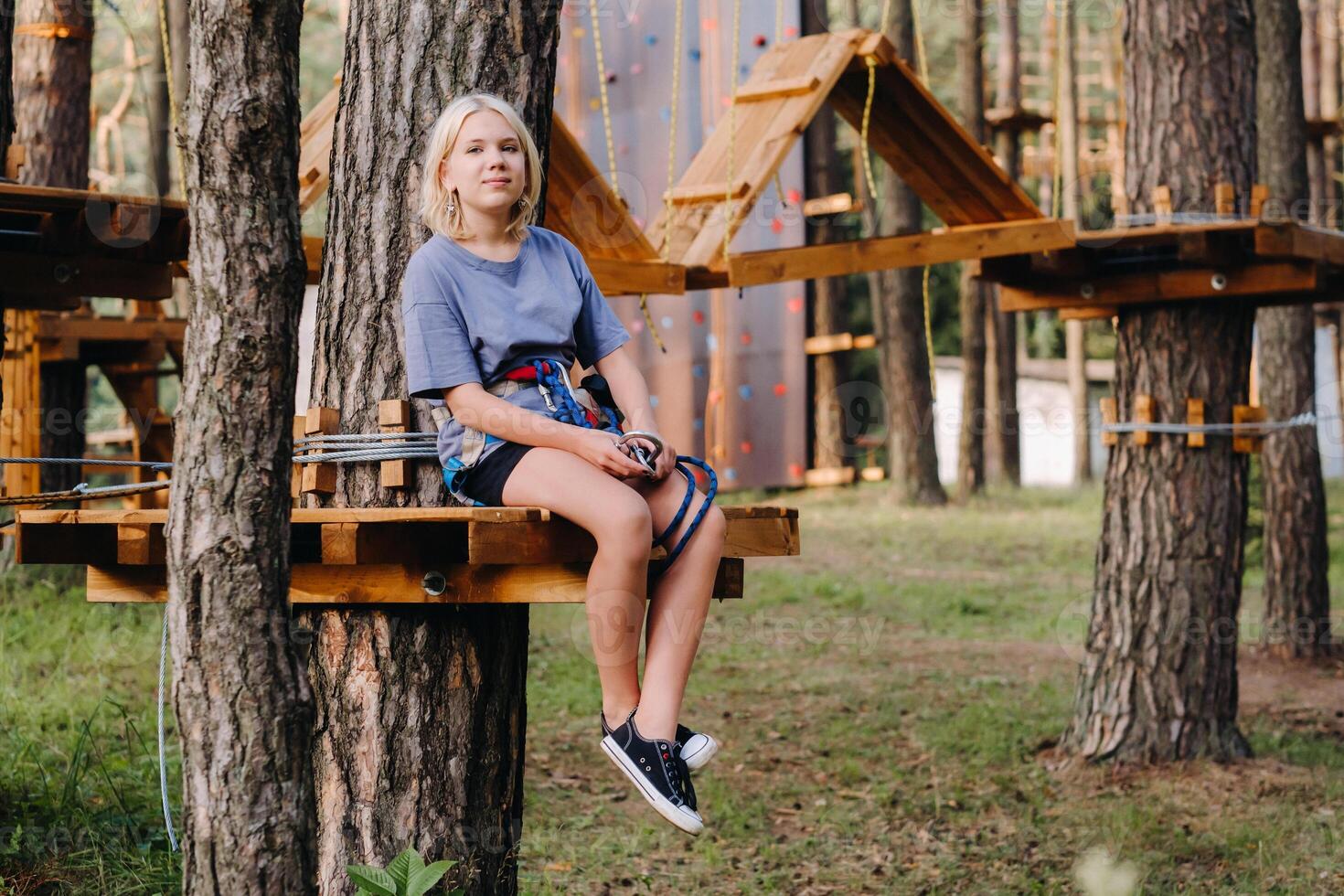 A girl passes an obstacle in a rope town. A girl in a forest rope park photo
