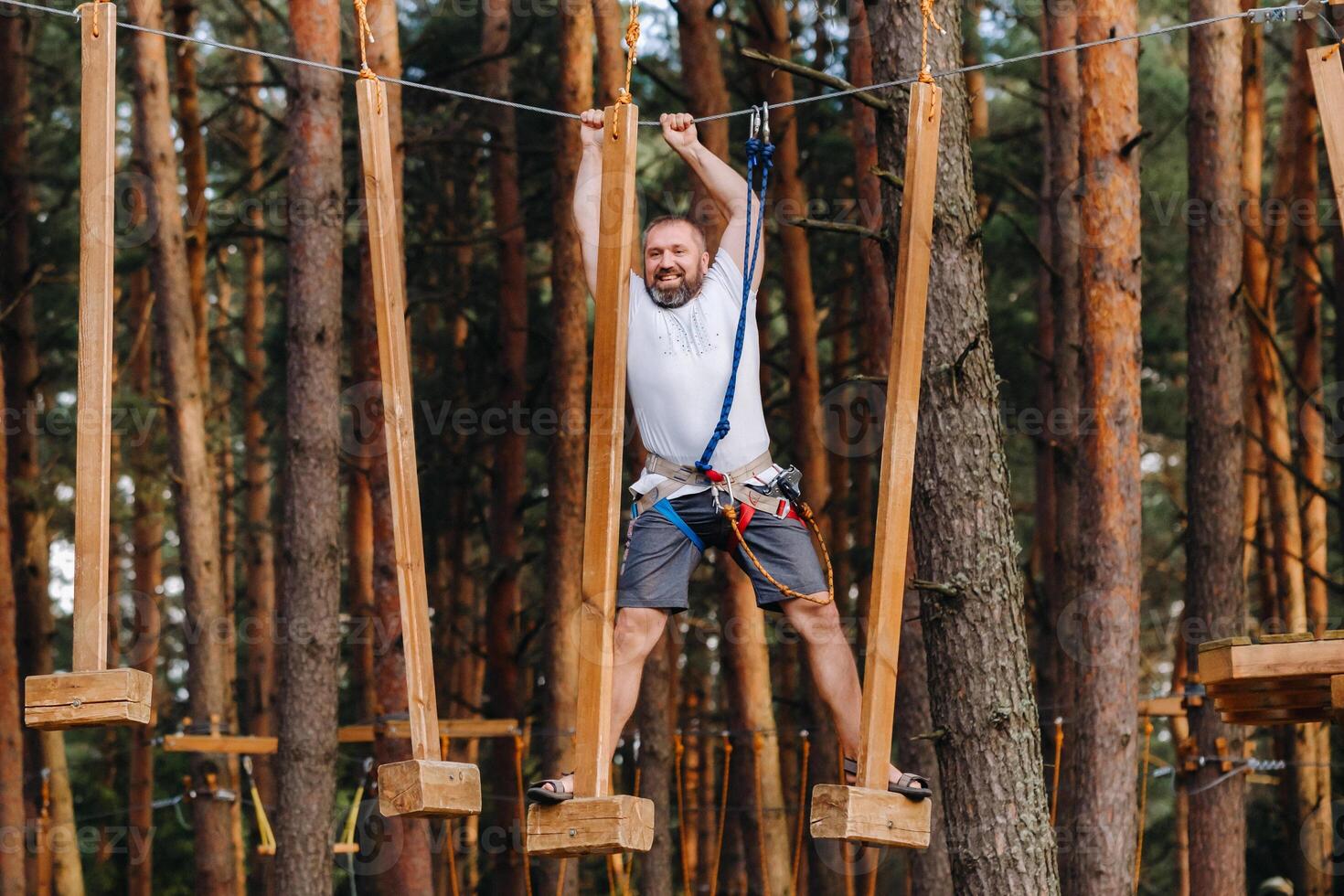 A man overcomes an obstacle in a rope town. A man in a forest rope park photo