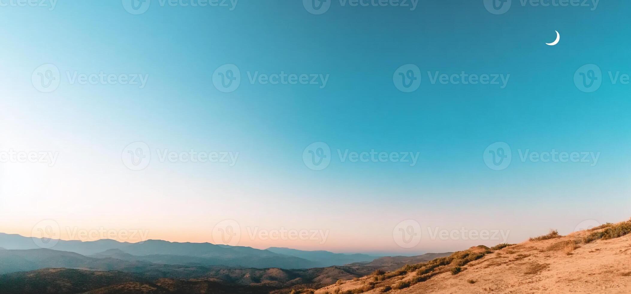 A view of the moon and the mountains at sunset photo
