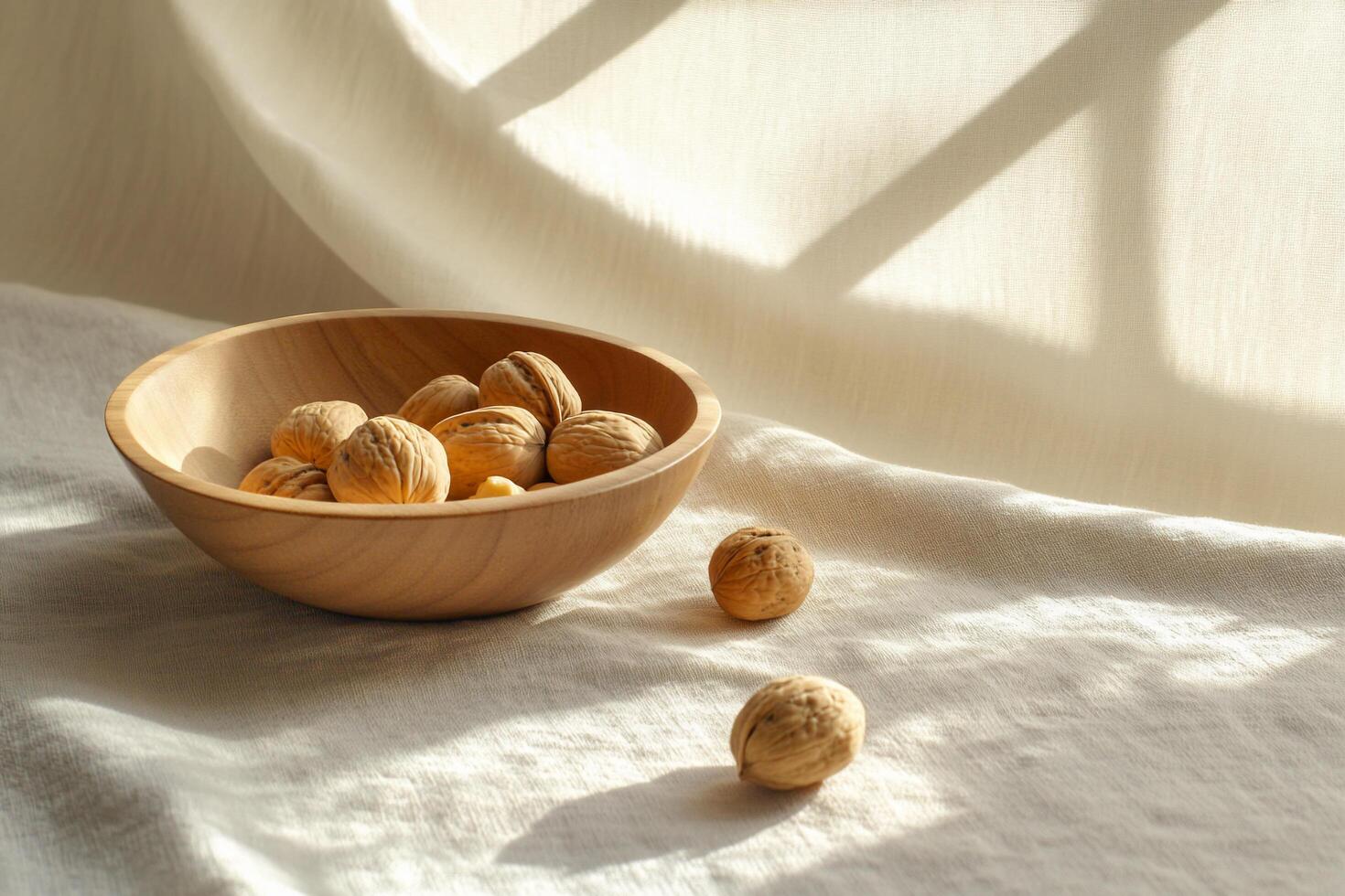 A wooden bowl with walnuts on a white cloth photo
