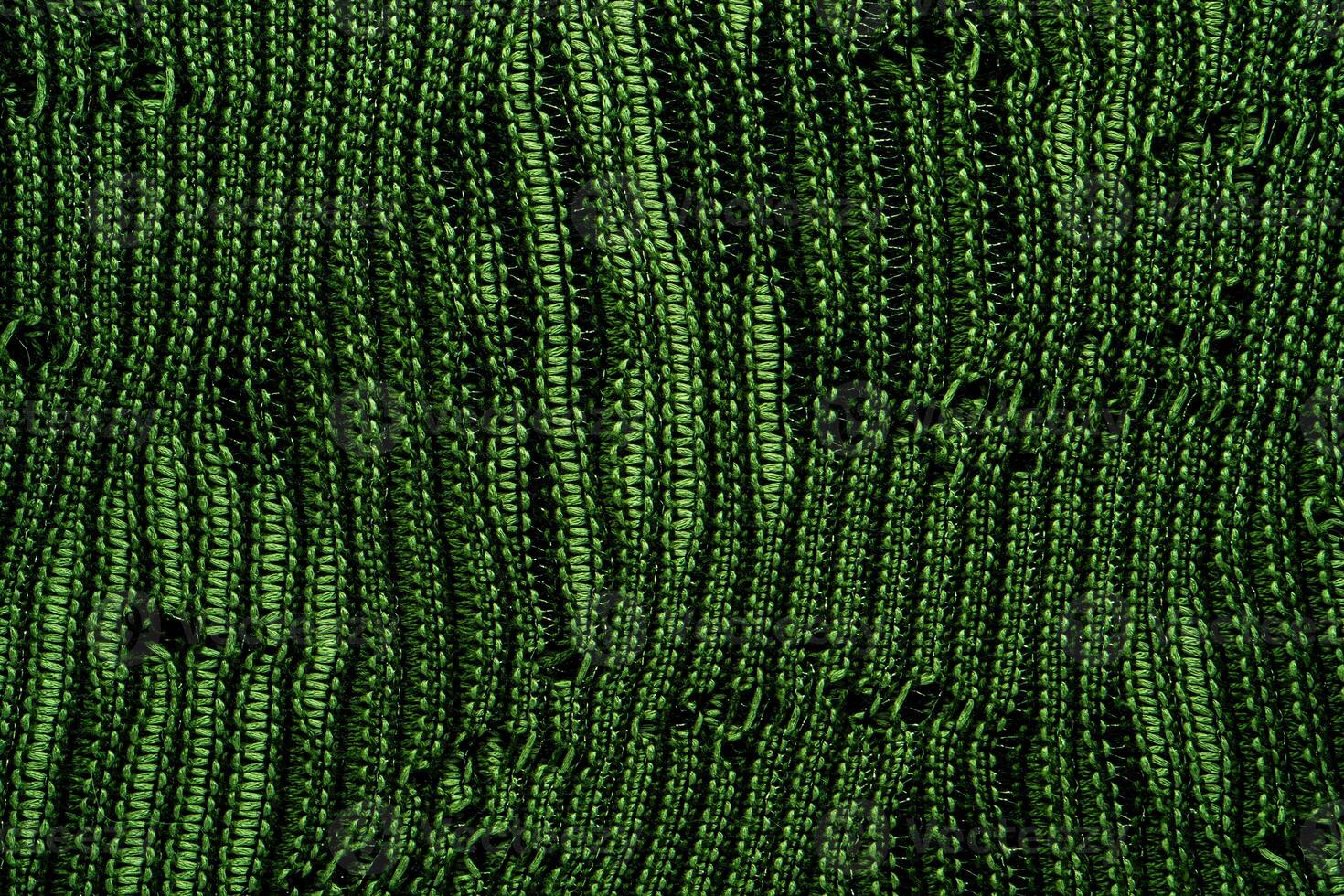 A close-up of green knitted fabric texture, detailed pattern, and vibrant color, suitable for backgrounds. photo