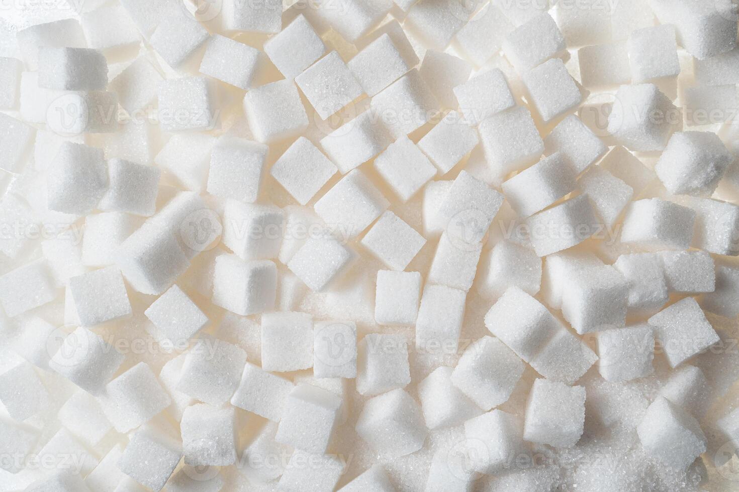 Cubes of refined white sugar, neatly arranged on a white background. photo