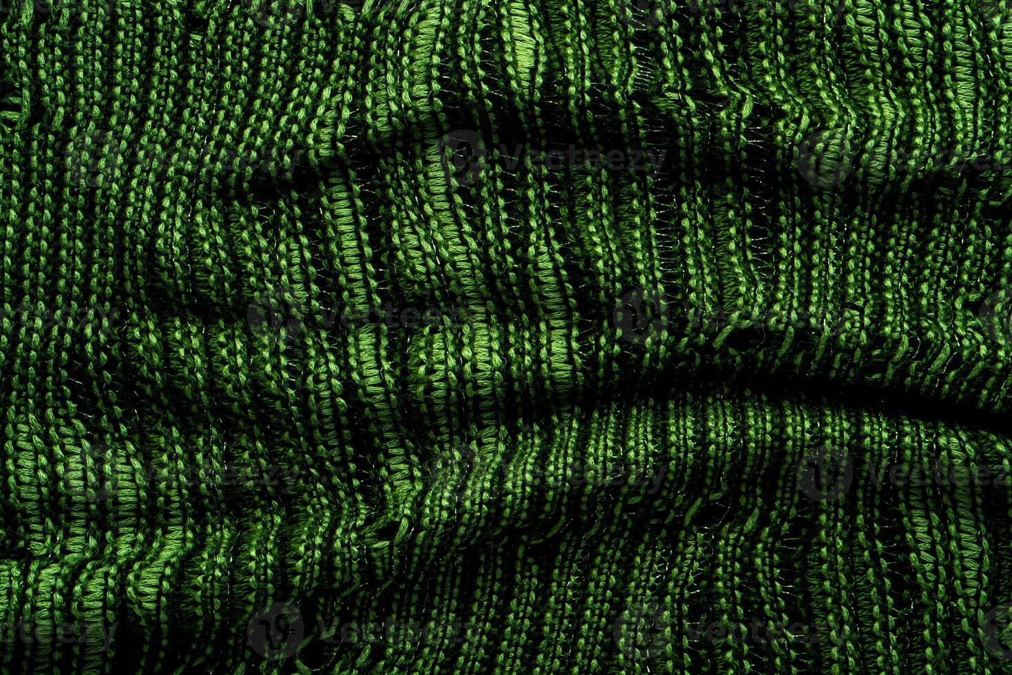A close-up of green knitted fabric texture, detailed pattern, and vibrant color, suitable for backgrounds. photo