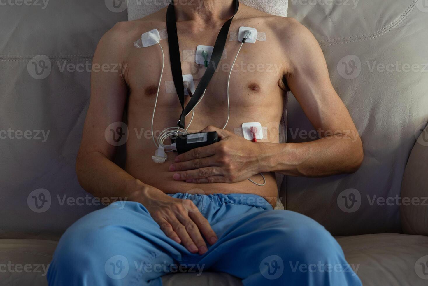 debt defaulting crisis concept. Male patient wearing a portable heart monitor with electrodes attached to the chest. Holter device is used for health diagnostics and monitoring cardiac activity. photo