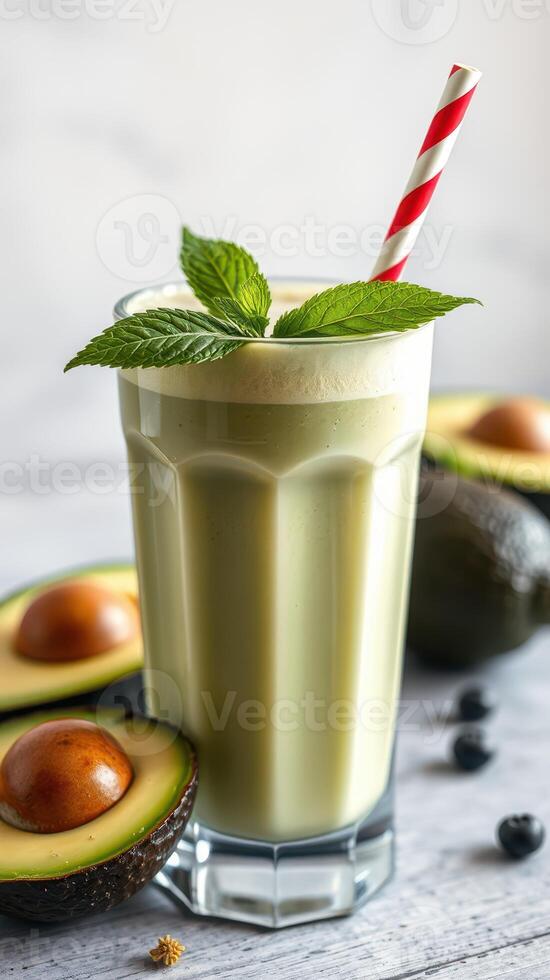 Refreshing avocado smoothie with mint garnish and fruit on the table photo
