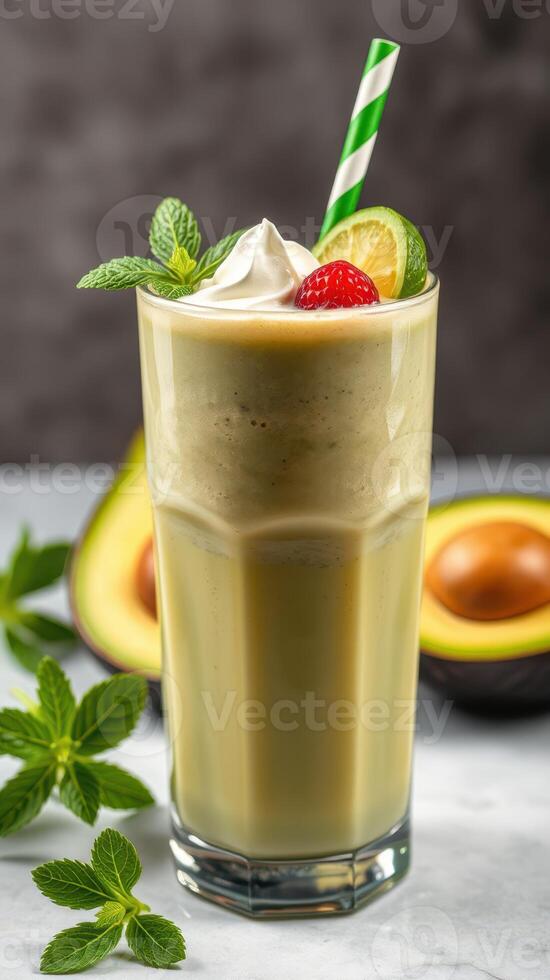 Refreshing avocado smoothie topped with cream, garnished with mint and fruit in a glass photo