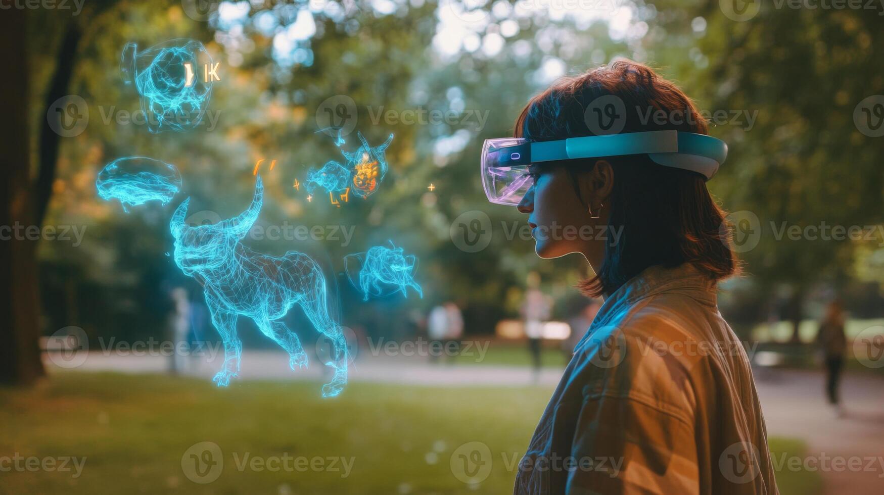 A young woman with short dark hair wears a light brown jacket and a virtual reality headset. She stands in an evening park, seemingly observing a holographic projection of several wireframe animals. photo