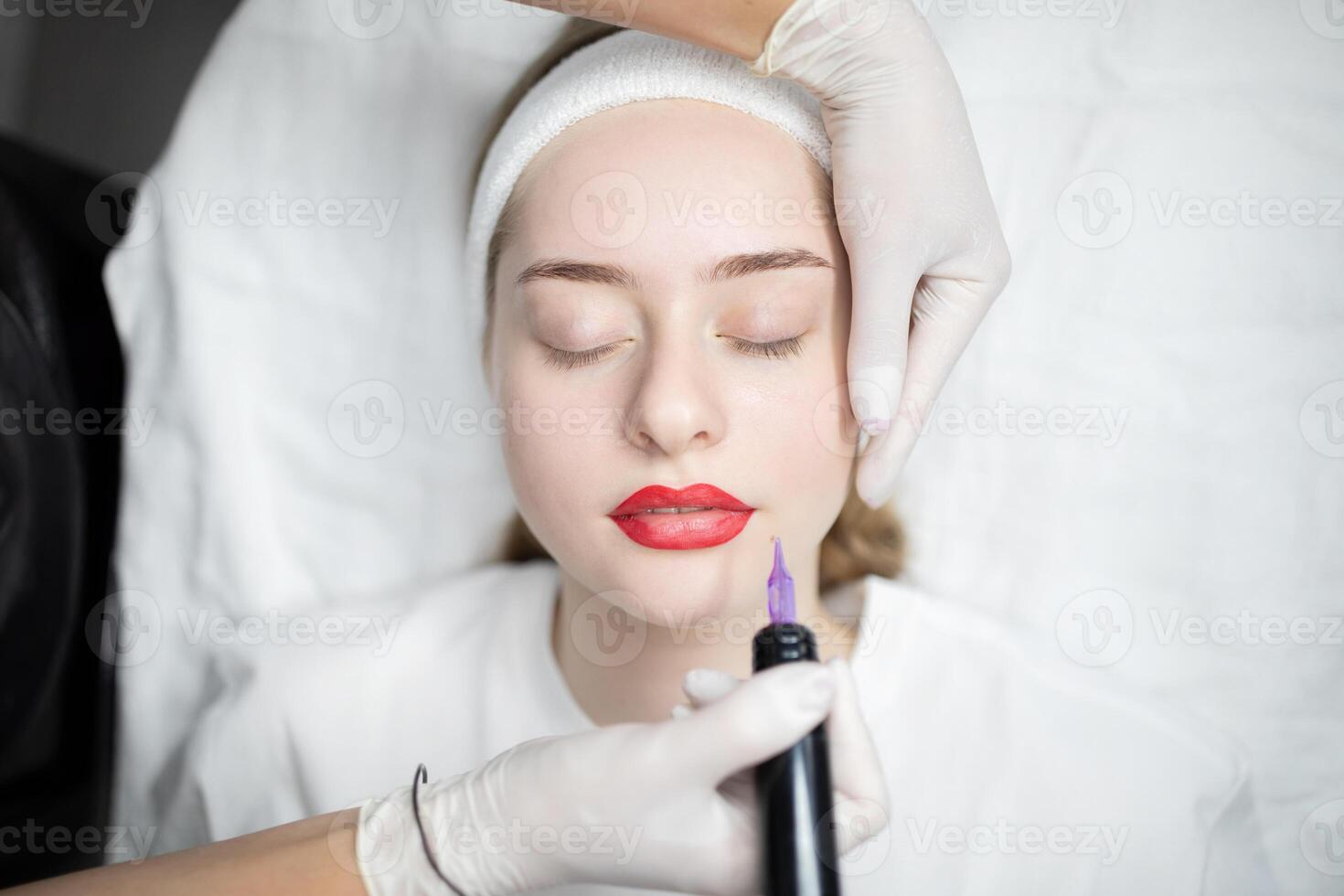 A woman relaxes in a beauty salon during a permanent makeup procedure. A skilled technician applies long-lasting makeup to enhance her features, providing a pampering experience. photo