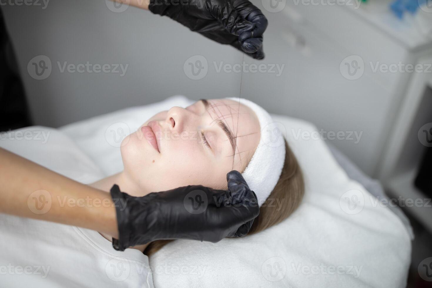 Two woman engage in a professional pampering session at a beauty salon, focusing on a long-lasting makeup procedure. The serene atmosphere creates a relaxing experience. photo