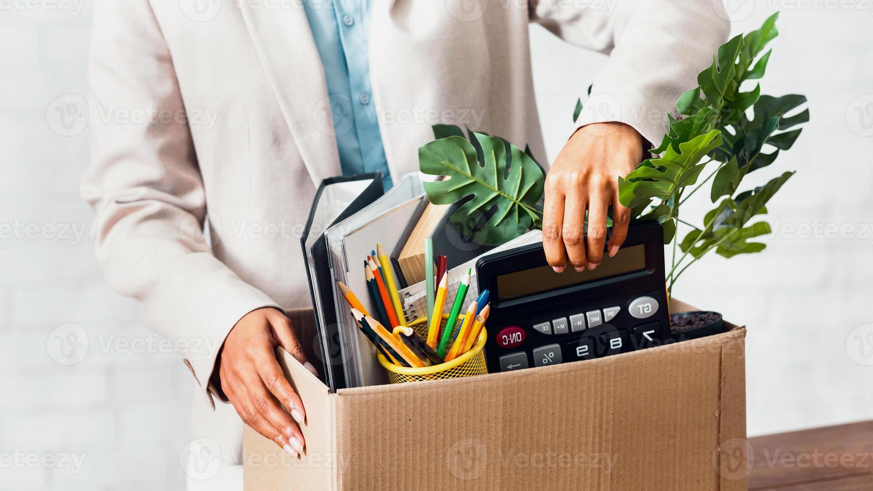 Leaving work concept. Closeup view of African American woman with cardboard box of stuff at office photo