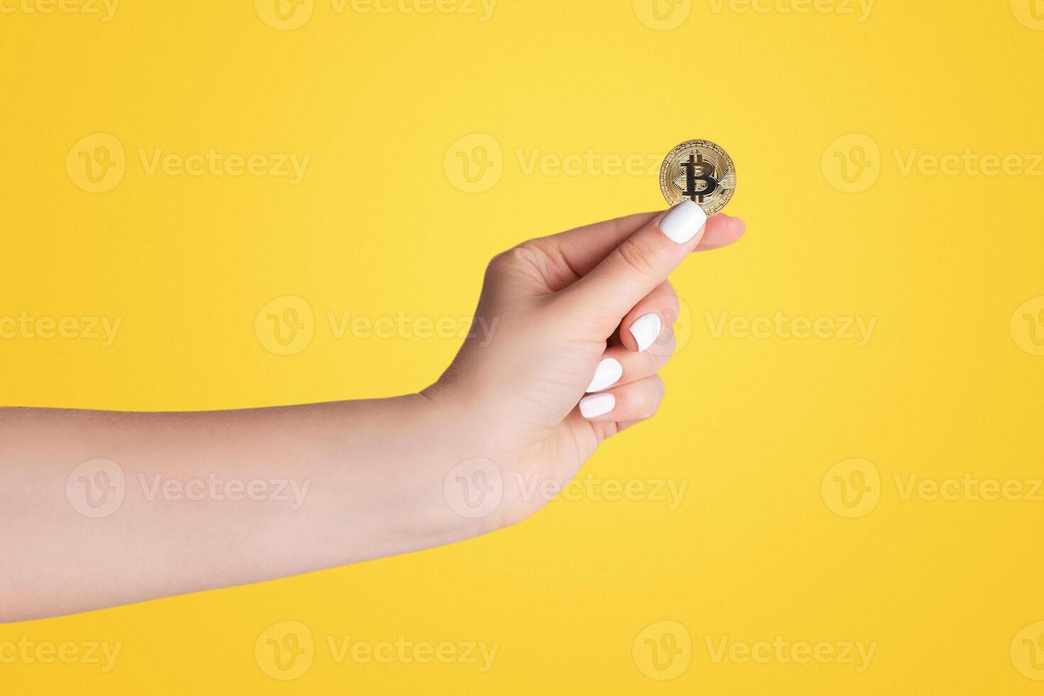 Closeup of millennial woman holdng bitcoin on light background photo