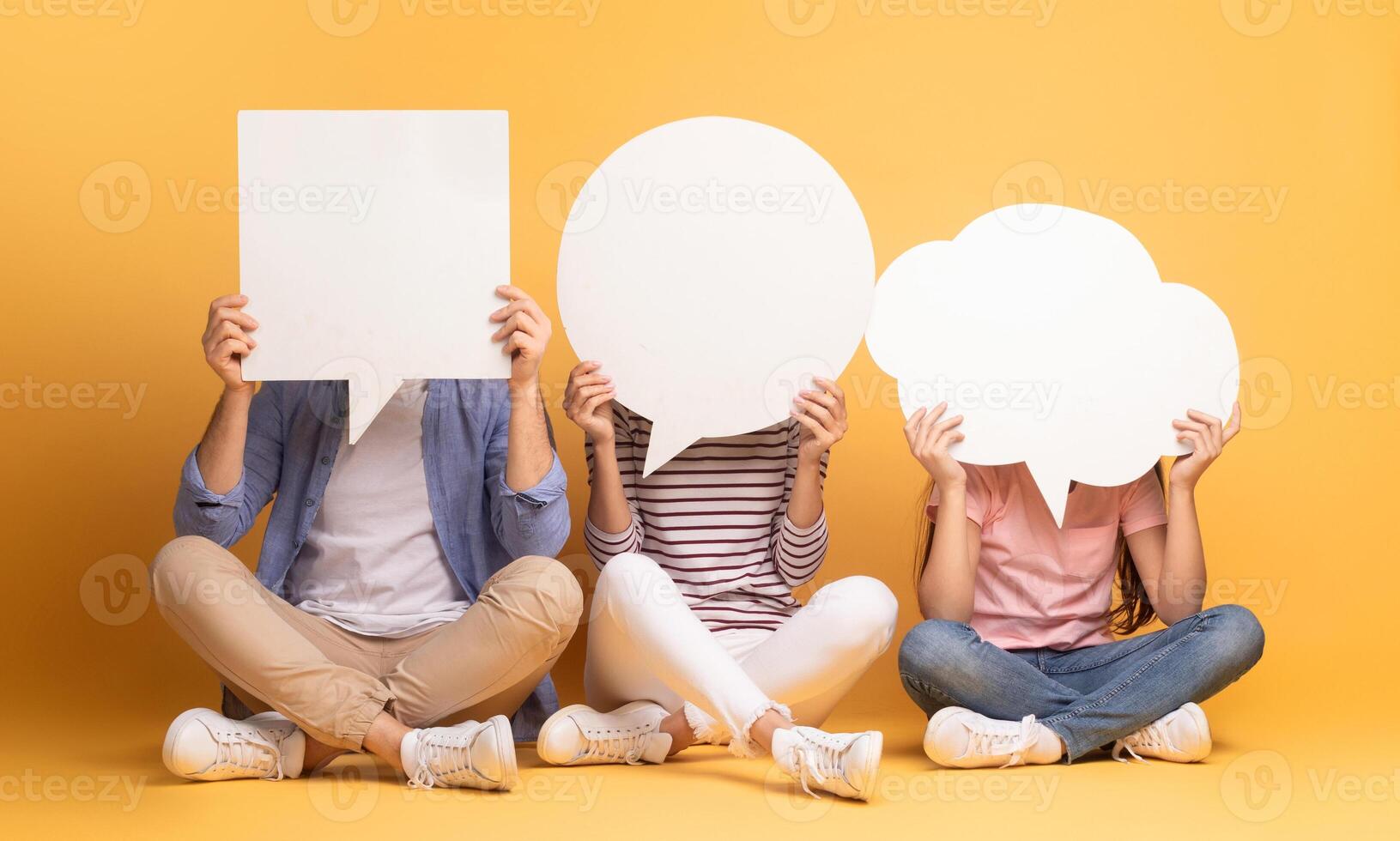 A family of three, including a mother, father, and teenage daughter, sits together against a vibrant yellow background. photo